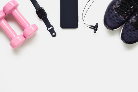 Fit health lifestyle and weight lose diet background concept. Fitness equipment running shoes, dumbbells, smartwatch, smartphone, earphone on white background.の写真素材