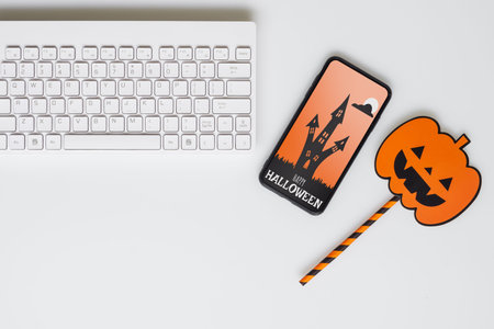 Happy Halloween Mobile phone mockup background concept. Top view of smartphone on office desk table...