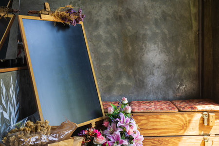 Blank mockup chalk board, sign board with flower bouquet in a loft style shop for your advertisement text or artwork.の写真素材