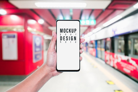 Mockup of hand using mobile phone with copy space blank screen for your advertisement with blurred...