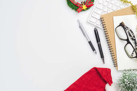 Merry Christmas and Happy new years office work space desktop concept. Flat lay top view with keyboard, red hat, glasses and Christmas ornaments with copy space.の写真素材