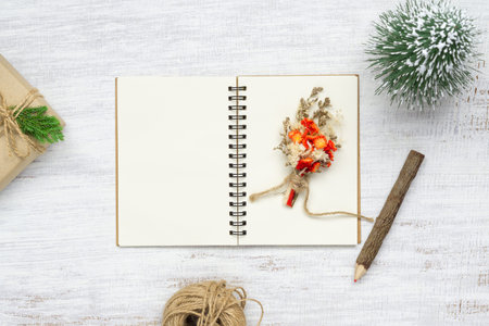 Top view of blank  notebook on grunge white wood  background with xmas toy decorations. Mockup...