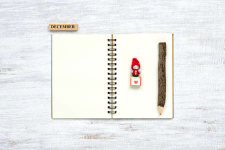 Top view of blank  notebook on grunge white wood  background with xmas toy decorations. Mockup Christmas background with notebook for wish list or to do list. Flat lay with copy space.の写真素材