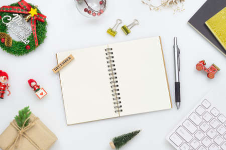 Top view of blank notebook on white  background with xmas decorations. Mockup Christmas background with notebook for wish list or to do list. Flat lay with copy space.の写真素材