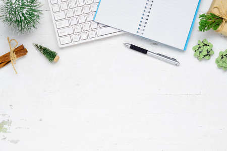 Merry Christmas and Happy new years office work space desktop concept. Flat lay top view with keyboard, blank notebook and Christmas ornaments with copy space.の写真素材