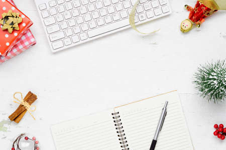 Merry Christmas and Happy new years office workspace desktop concept. Flat lay top view with keyboard, blank notebook and Christmas ornaments with copy space.の写真素材