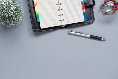 Top view of blank notebook, mini Christmas tree and Christmas ornament ball on gray  background. Flat lay with copy space.の写真素材
