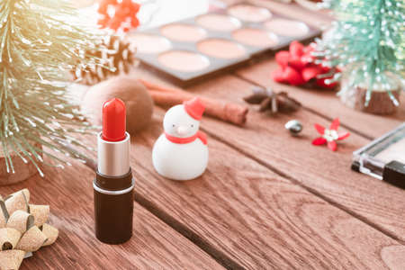 Close up of lipstick and woman cosmetic with Christmas ornamets decoration on wood with copy space.の写真素材