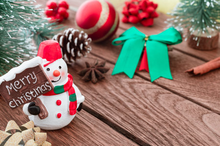 Close up of Snowman with Merry Christmas sign  and Christmas ornamets decoration on wood with copy...