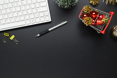 Merry Christmas and Happy new years office work space desktop shopping concept. Flat lay top view with keyboard, mini shopping cart and Christmas ornaments with copy space.の写真素材