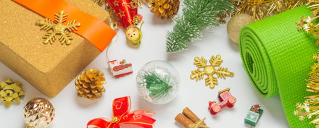 Green yoga mat or pilates mat with Christmas ornaments decoration for web banner. Christmas best gift for healthy lifestyle people concept. Yoga xmas and happy new year background.の写真素材
