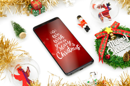 Mockup smartphone Christmas background with Christmas ornaments on white background. Xmas festive...