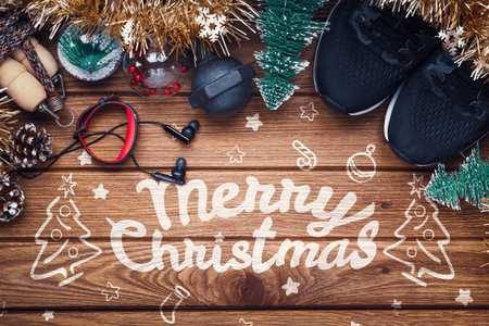 Exercise, Fitness and Working Out Merry Christmas and Happy new year Festive healthy lifestyle background concept. Dumbbells, running shoes, jump rope, sports watch and Christmas ornaments decorate on wood background.の写真素材