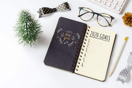 2020 New Year Resolution Goals List Concept. Business office desk with notebook written in...