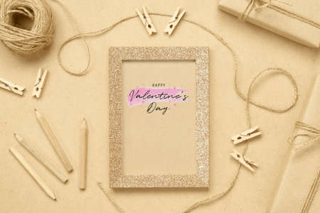 Mockup photo frame with kraft present boxes for Valentines day concept. Top view of mock up photo frame with craft decoration and on wood background. Flat lay top view with copy space.の写真素材