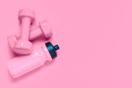 Fitness workout background concept with pink dumbbells and bottle of water. Top view flatlay sport,...