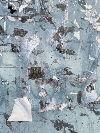 Abstract background of  grunge dirty wall. Traces of papers were torn from a rusty light blue metal...