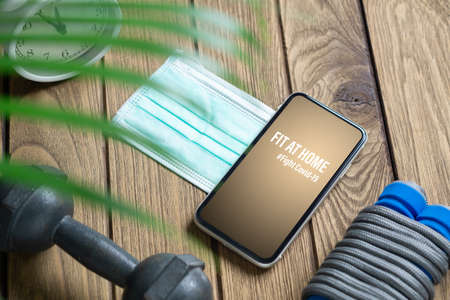 Fit At Home, Healthy at home for quarantine times in Coronavirus pandemic outbreak background concept. Mockup mobile phone for Be Active during virus pandemic. Fight Covid-19の写真素材