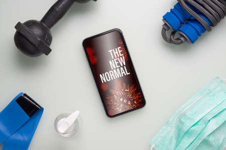 The New Normal healthy and fitness during quarantine times in Coronavirus Covid-19 pandemic outbreak background concept. Mockup mobile phone for fit and workout at Home, Be Active during virus pandemic.の写真素材