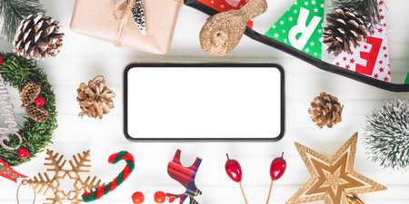 Mockup blank white screen smartphone on white desk background for Christmas. Wide Angle Template for...