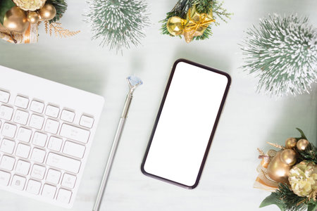 Mockup blank white screen smartphone on home office desk with computer keyboard on white background...