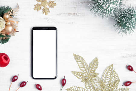 Mockup blank white screen smartphone on white wood background for Christmas and New Year party background, Flat lay top view with copy space for your Merry Christmas and Happy New year artwork.の写真素材
