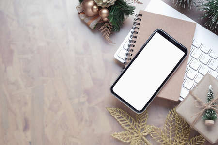 Mockup blank white screen smartphone on home office desk background for Christmas and New Year background concept, Flat lay top view with copy space for your Merry Christmas and Happy New year artwork.の写真素材