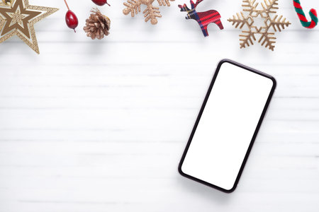 Mockup blank white screen smartphone on white desk background for Christmas and New Year background...