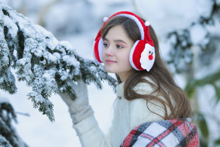 A young girl walks in the winter forest with a basket of mandarin.の写真素材