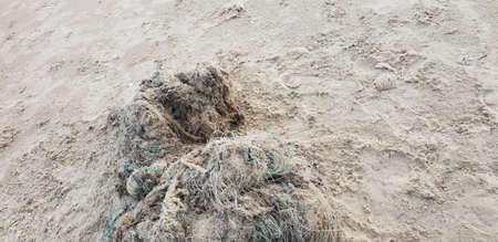 Old fishermanâs net laying on the sand in beachの写真素材