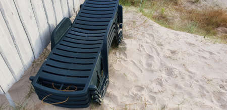 Stacked sun beds laying in the Baltic sea beach near changing room.の写真素材