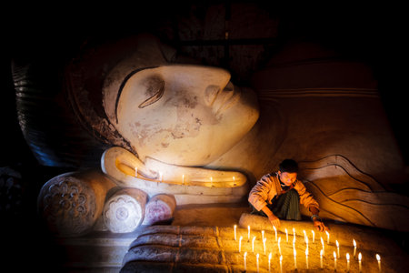 BAGAN - MYANMAR - November 15, 2013: Unidentified Burmese boy praying with candle light in a Buddihist temple on November 15, 2013 in Bagan, Myanmar. 89% of the Burmese population is Buddhist.

のeditorial素材