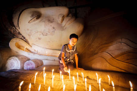 BAGAN - MYANMAR - November 15, 2013: Unidentified Burmese girl praying with candle light in a Buddihist temple on November 15, 2013 in Bagan, Myanmar. 89% of the Burmese population is Buddhist.

のeditorial素材