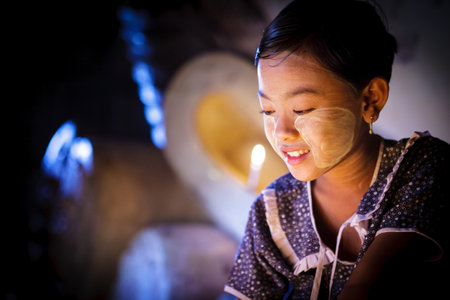 BAGAN - MYANMAR - November 15, 2013: Unidentified Burmese girl praying with candle light in a Buddihist temple on November 15, 2013 in Bagan, Myanmar. 89% of the Burmese population is Buddhist.

のeditorial素材