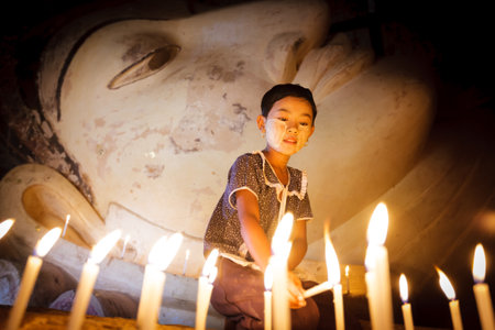 BAGAN - MYANMAR - November 15, 2013: Unidentified Burmese girl praying with candle light in a Buddihist temple on November 15, 2013 in Bagan, Myanmar. 89% of the Burmese population is Buddhist.

のeditorial素材