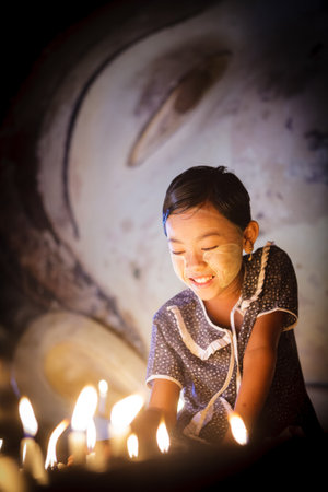 BAGAN - MYANMAR - November 15, 2013: Unidentified Burmese girl praying with candle light in a Buddihist temple on November 15, 2013 in Bagan, Myanmar. 89% of the Burmese population is Buddhist.

のeditorial素材