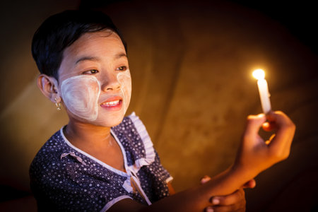 BAGAN - MYANMAR - November 15, 2013: Unidentified Burmese girl praying with candle light in a Buddihist temple on November 15, 2013 in Bagan, Myanmar. 89% of the Burmese population is Buddhist.

のeditorial素材