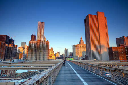 Lower Manhattan through Brooklyn Bridge at sunset, New York City - United Statesの写真素材