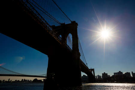 Silhouette view of Brooklyn Bridge with sun starの写真素材