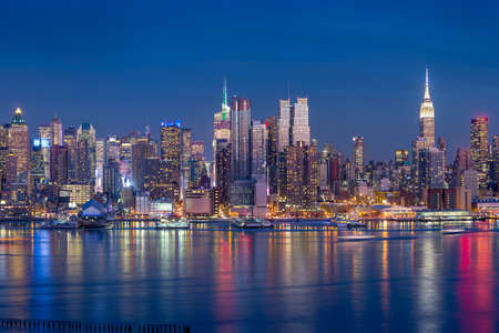 New York City with skyscrapers illuminated over Hudson River panoramaの写真素材
