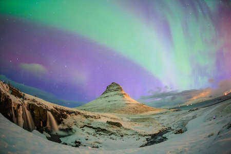 Spectacular northern lights appear over Mount Kirkjufell and waterfall in Iceland.の写真素材