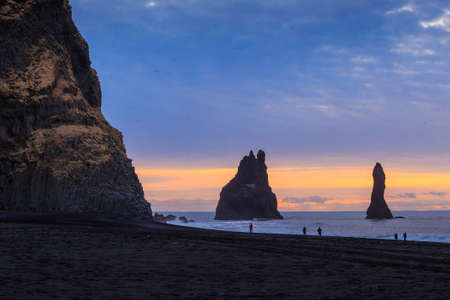 view of Reynisdrangar rock formations on Reynisfjara Beach at sunrise, Vik, Iceland.