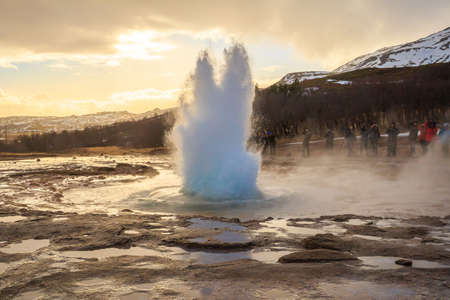 The Strokkur geyser in Iceland is erupting at sunsetの写真素材