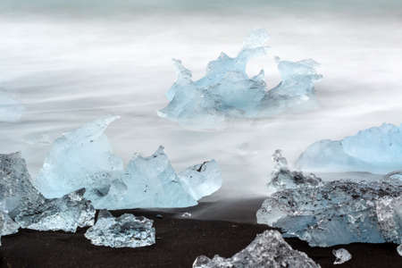 Beautiful beach in the South of Iceland with a black lava sand with icebergs from glaciers