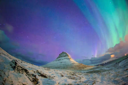 Spectacular northern lights appear over Mount Kirkjufell and waterfall in Iceland.の写真素材