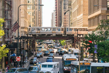 Traffic in downtown Chicago with people, train, car and busの写真素材