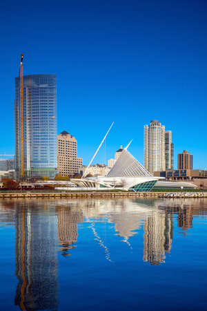Milwaukee skyline  with city reflection in lake Michigan and harbor pier.のeditorial素材