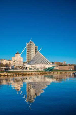 Milwaukee skyline  with city reflection in lake Michigan and harbor pier.のeditorial素材