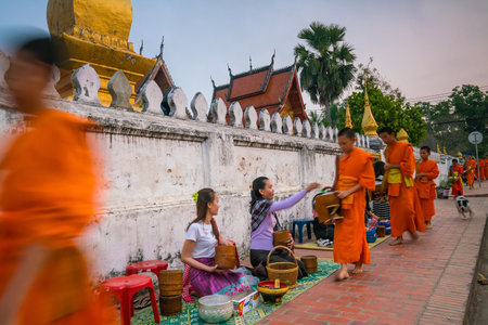 LUANG PRABANG, LAOS - FEB 10: Buddhist monks collecting alms in the morning. The tradition of giving alms to monks in Luang Prabang has been extended to tourists on Febuary 10, 2017のeditorial素材