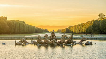 Garden of Chateau de Versailles and Apollo's fountain, near Paris in France at sunset